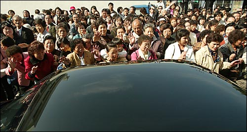 오웅진 신부가 탄 승용차가 떠나자 수백명의 교우들이 손을 흔들고 있다. 